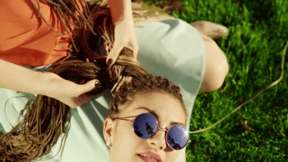 Young Hipster Girls Relaxing on the Grass in Park