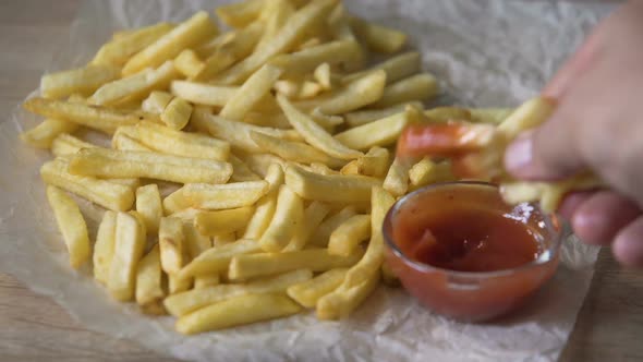 Back View of Man Chewing French Fried Potatoes and Dunking in Tomato Sauce