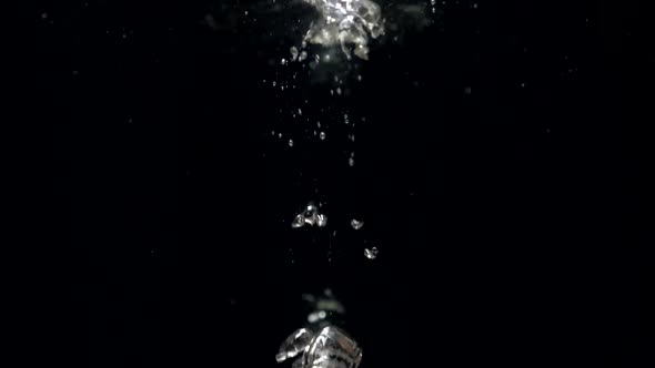 Slow Motion Air Bubbles in Water Rising Up to Surface on Black Background