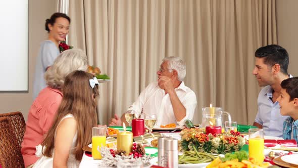 Proud mother bringing roast turkey to the christmas dinner table