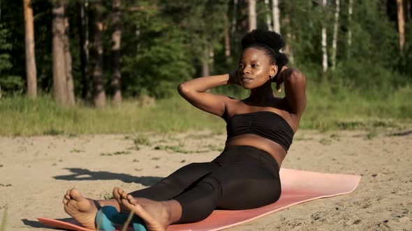 Athletic Black Girl in Sportswear Shakes Her Abdominals. Training, Workout and Wellness Concept.