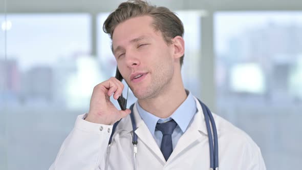 Portrait of Young Male Doctor Talking on Smartphone in Office 