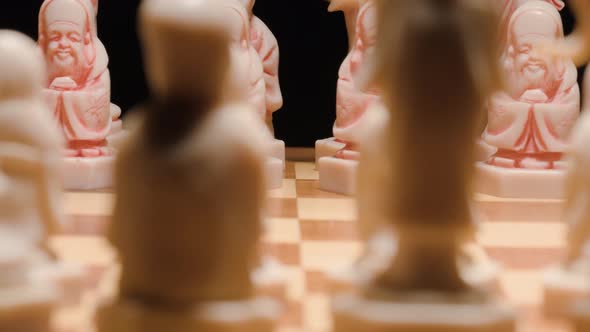 Chess ivory figures revealing, Tracking tilt up, Extreme close up. Chessboard Pieces