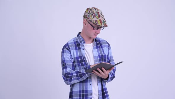 Happy Young Hipster Man with Eyeglasses Reading Book