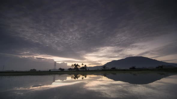 Timelapse cloudy morning over the reflection of Bukit Mertajam hill 