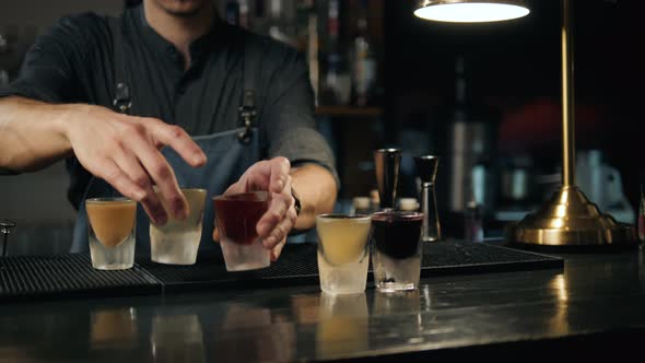 Beautiful Row Line of Different Colored Alcohol Cocktails Bartender on a Party Martini Vodka and