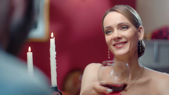 Face Smiling Beautiful Woman with Bocal of Red Wine Looking on Man