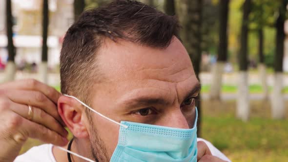 Closeup of the Face of a Young Man Wearing a Medical Mask
