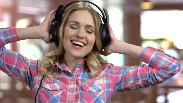 Young Girl Listening To Music in Big Headphones