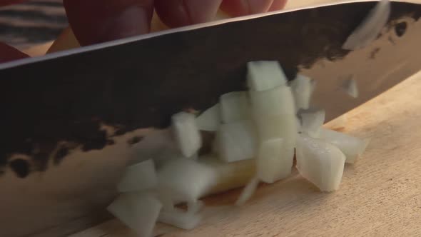Super Closeup of the Knife Cutting a White Onion Into Cubes