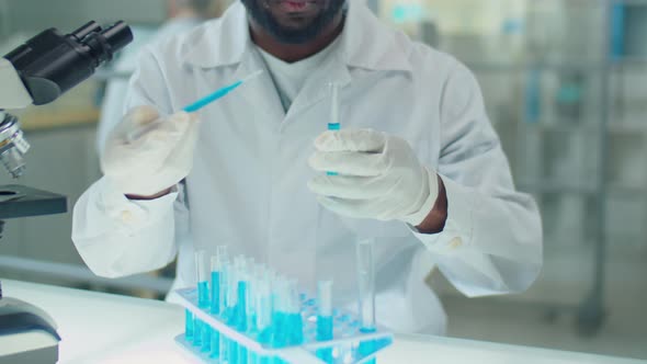 African American Scientist Working Blue Chemical in Lab