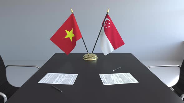 Flags of Vietnam and Singapore and Papers on the Table