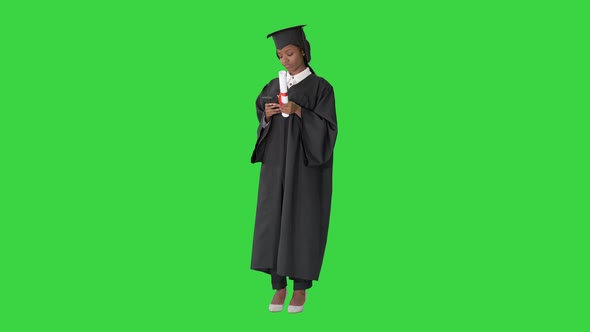 Happy African American Female Graduate Holding Diploma and Making Selfie on a Green Screen Chroma