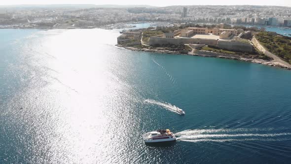 Touristic boats sailing on pristine Mediterranean Sea, Valletta, Malta