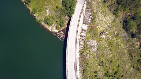 Overhead Aerial Drone Shot Following a Road on a Seaside Dam.