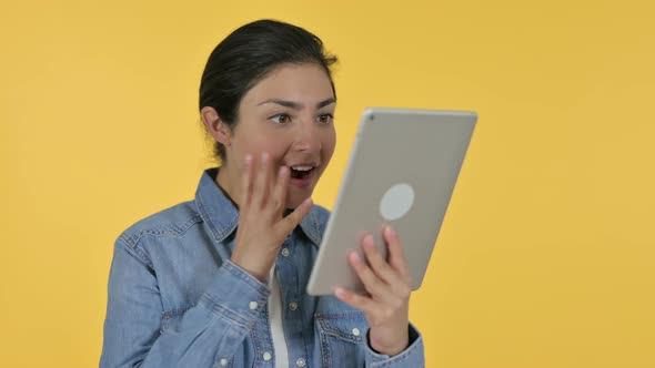 Indian Woman Celebrating on Tablet, Yellow Background 