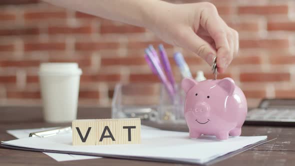 Vat is Word Written on Wooden Cubes Lying on Table on Brick Background