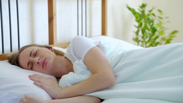 Woman with Insomnia Can't Sleep at Night. She Tosses and Turns in Bed