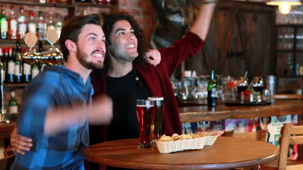 Friends cheering while having beer