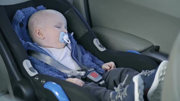 Cute Baby Sleeping in Car Seat during Road