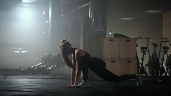 A Woman Does Stretching Exercises in a Dark Fitness Room After a Workout Fitness Woman Working Out