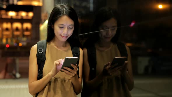 Woman use of smart phone in city at night 