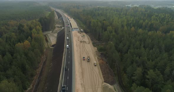 New Highway Road Construction Between Green Forest Aerial View Drone Shot