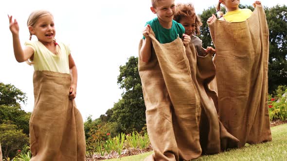 Kids having a sack race in park