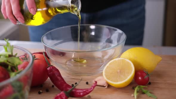 Making Salad Sauce  Pouring Olive Oil Into Glass Bowl