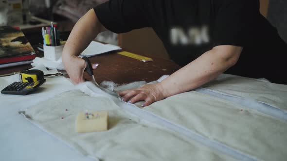 Closeup Female Hands Cutting Foam Rubber with Scissors for the Production of a Sofa in a Furniture