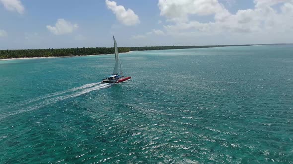 Aerial Footage of a Luxury Sailing Yacht Moving Along the Shore Tropical