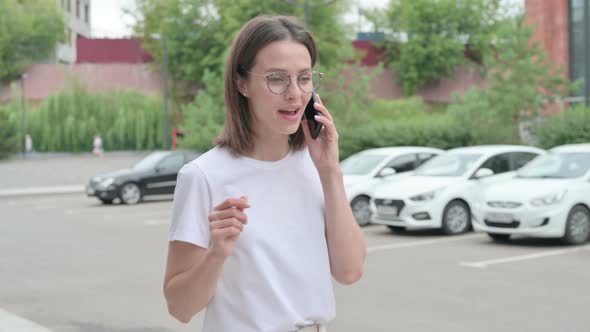 Woman Talking on Phone while Going to Office