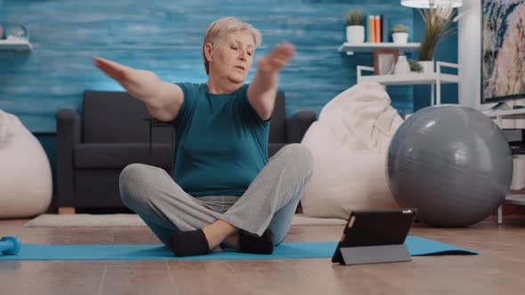 Senior Woman Watching Training Lesson on Tablet to Exercise