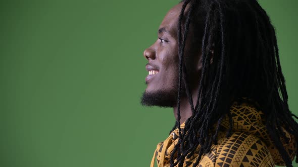 Young Handsome African Man with Dreadlocks Against Green Background