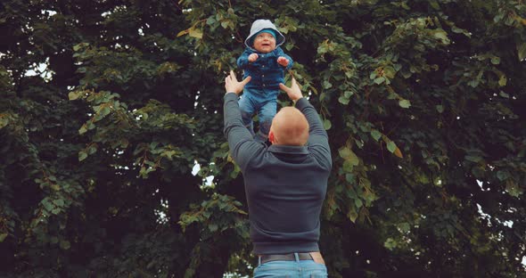 Dad Playing with His Son Throws Him Up and Catch Him