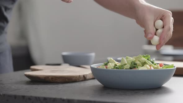 Slow Motion Man Make Salad with Kale Mozzarella Avocado and Cherry Tomatoes Add Mozzarella