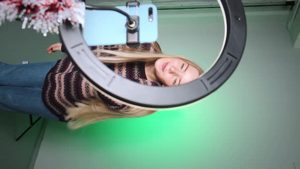 A Girl with White Hair Shoots a Video for Social Media Using Her Phone and Light