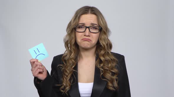 Lady Holding Paper Stick Expressing Awful Mood Then Takes Another Expressing Good Mood on Gray