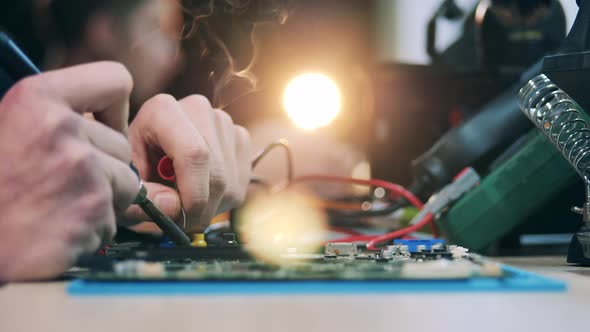 Repairman's Hands While Soldering a Circuit in a Close Up