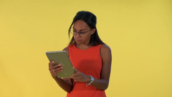 Black Business Woman in Dress and Eyeglasses Analysing Something on Tablet