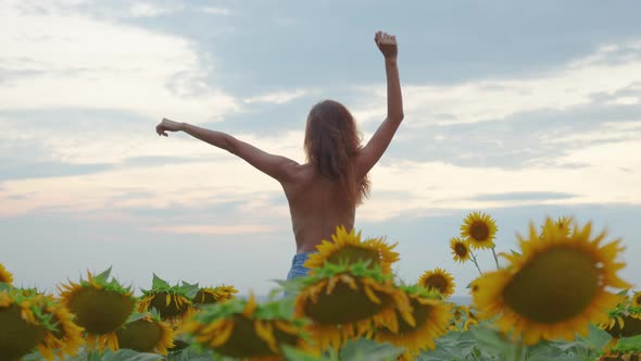 Happy Woman in the Field with Sunflowers