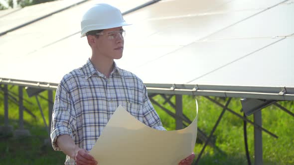 Engineer in a White Helmet is at the Solar Power Station