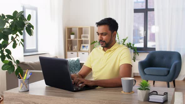 Happy Man with Laptop Working at Home Office