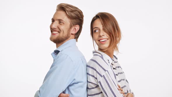 Beautiful Caucasian Pair Standing Back to Back Flirtring Laughing on White Background