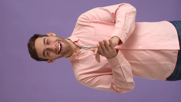 Vertical Studio Portrait of Enthusiastic Young Man Clapping Hands Showing Appreciation Looking at