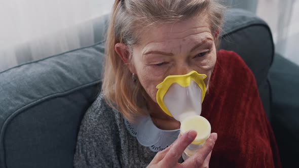 Sick Old Woman Inhaling Oxygen at Home
