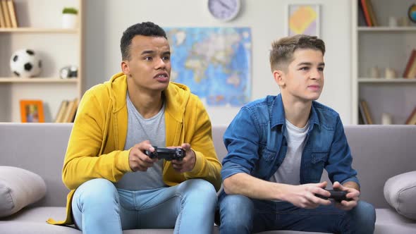 Emotional Multiracial Male Teen Friends Playing Video Game, Hobby and Rivalry