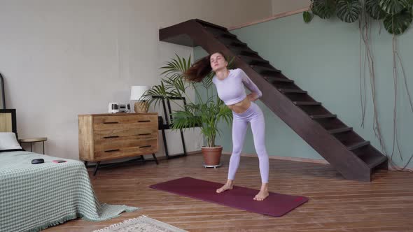 a Young Woman Doing Gymnastics at Home in a Tight Lilac Suit