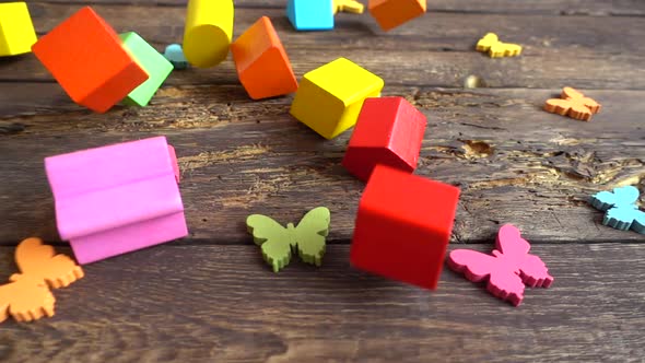 Children's play wooden figures fall on a vintage board. Slow motion.