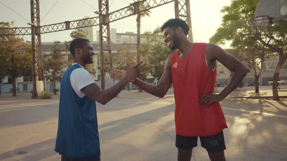 Cinematic footage of a street basketball game outdoor.